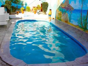a swimming pool with a painting on the side of a building at Fully equipped villa Near Agadir in Agadir