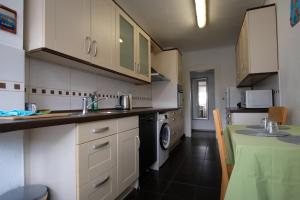 a kitchen with white cabinets and a sink and a dishwasher at Ferienwohnung Kaspar mit Parkplatz in Pforzheim