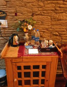 a wooden table with two bottles of water on it at Meraki Huts in Pauri