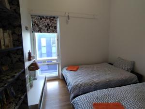 ヘルシンキにあるHelsinki Penthouse near the west harborのベッド2台と窓が備わる小さな客室です。