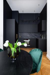 a dining room with a black table with a vase of flowers at TurnKey I Premium Apartment in Prague