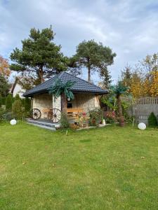 a small house in a yard with a green lawn at Amonit in Olsztyn
