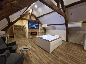 a living room with a white couch and a table at Suite Chalet avec jacuzzi YaoSpa60 in Laigneville