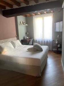 a bedroom with a large white bed and a window at Le Camere di Bsuites Affittacamere in Parma