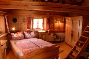 um quarto com uma cama num chalé de madeira em Beim Dokterer, Fewo ANNO DAZUMAL em Halblech