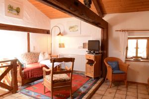 a living room with a couch and a tv at Beim Dokterer, Fewo ANNO DAZUMAL in Halblech