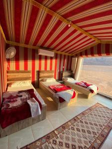 Un dormitorio con dos camas y una gran ventana. en Mountain Magic Camp Wadi Rum, en Wadi Rum
