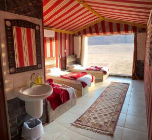 baño con 2 camas y lavabo en una habitación en Mountain Magic Camp Wadi Rum en Wadi Rum