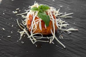 a pastry with cheese and a green leaf on top at I Carusi Relais in Noto