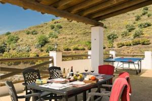 een tafel en stoelen op een patio met een tafel en een tafeltennistafel bij VILLA CASANOVA in Nerja