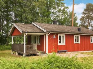 uma casa vermelha com um banco à frente em Holiday home SÖLVESBORG XVI em Sölvesborg