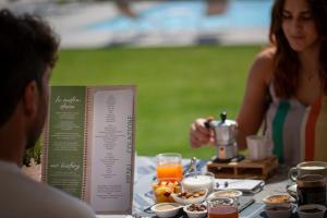 a man and a woman sitting at a table with food at I Carusi Relais in Noto