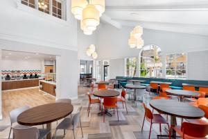 a restaurant with tables and chairs and a bar at Clementine Hotel & Suites Anaheim in Anaheim