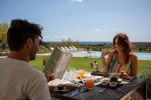 a man and a woman sitting at a table with food at I Carusi Relais in Noto
