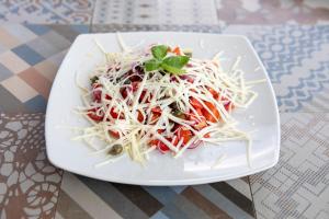 a white plate with a salad on a table at I Carusi Relais in Noto