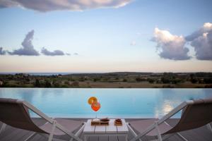 a table with a balloon and two chairs next to a lake at I Carusi Relais in Noto
