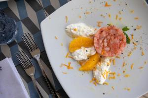 a white plate with food on a table with forks at I Carusi Relais in Noto