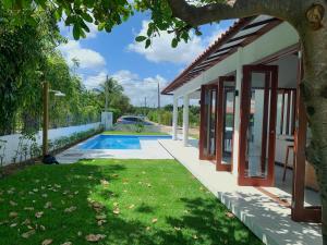 uma casa com piscina ao lado de um quintal em Casa do Bem - Deluxe 3 bedroom villa with pool. em Pipa
