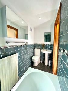 a bathroom with a tub and a toilet and a sink at Cosy 2 bed cottage on Dartmoor , Near Ivybridge in Plymouth