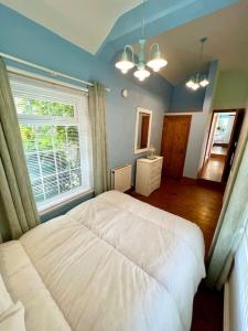 a bedroom with a white bed and a window at Cosy 2 bed cottage on Dartmoor , Near Ivybridge in Plymouth