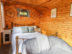 a bedroom with a bed in a log cabin at Hideaway Cabin in Exeter