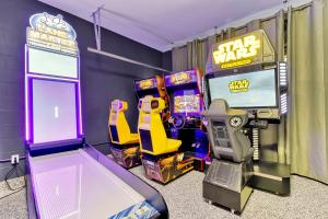 a video game room with a star wars arcade game at Tropical Nights - 8 bed ChampionsGate Resort family pool home in Davenport