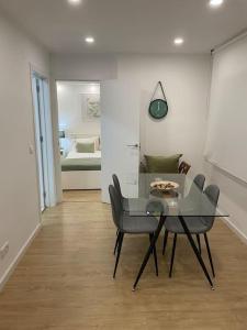 ein Esszimmer mit einem Tisch und Stühlen sowie ein Schlafzimmer in der Unterkunft Relax Sintra Home - Near Lisbon in Queluz