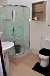 a bathroom with a shower and a toilet and a sink at Frankie’s Place: A spacious 4-bedroom home in Ondo