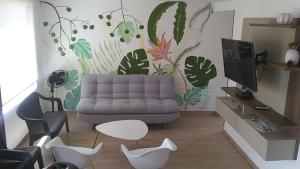 a living room with a couch and a wall with plants at Villa Campestre Lago Calima in Calima