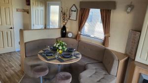 a living room with a couch and a table at STATIC CARAVAN N WALES LyonsRobinHood RHYL in Meliden