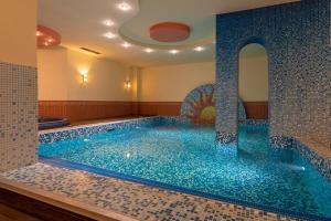 uma grande piscina num quarto com azulejos azuis em Хотел "Скалите", Skalite Hotel em Belogradchik