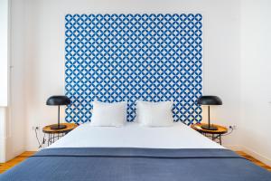 a blue and white bedroom with a bed and two chairs at WHome Alecrim 43 Top Location perfect to explore Lisbon in Lisbon