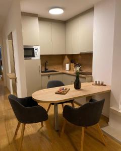 a kitchen with a wooden table and chairs in a kitchen at MA Apartment Jahorina in Jahorina
