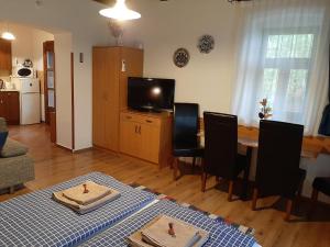 ein Wohnzimmer mit einem Tisch und einem Esszimmer in der Unterkunft Bodza Vendégház - Apartmanház in Demjén