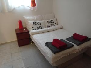 1 cama con 2 almohadas y toallas rojas. en Minigarzon, en Budapest