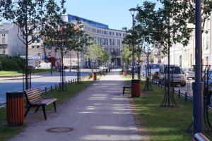 Przestronne mieszkanie w centrum Gdańska في غدانسك: حديقة بها مقاعد وأشجار في شارع المدينة