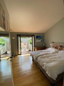 um quarto com uma cama grande e piso em madeira em Maison de ville entre amis ou en famille em Castelnau-le-Lez