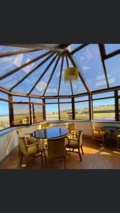 a room with a glass roof with tables and chairs at The Weigh Inn Hotel & Lodges in Thurso