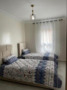 a bedroom with two beds and a window at Appartement meublé proche de la mer à Agadir in Agadir