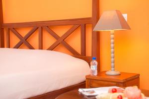 a bedroom with a bed and a table with a lamp at Casa Del Papa Resort & SPA in Azizacoue