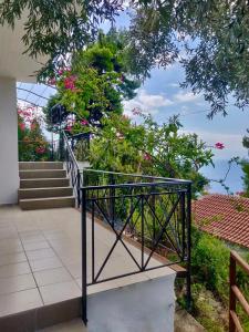史塔菲洛斯的住宿－Villa Myrto - Beautiful see-view villa，房屋内的阳台设有楼梯和鲜花