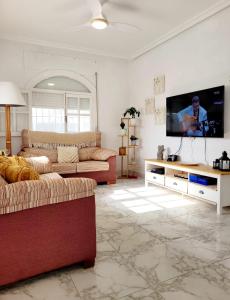 uma sala de estar com 2 sofás e uma televisão de ecrã plano em Casa Rural El Cornijal - Piscina Privada em San Javier
