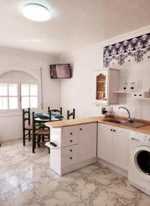 uma cozinha com um lavatório e uma máquina de lavar roupa em Casa Rural El Cornijal - Piscina Privada em San Javier