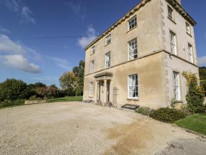 an old stone house with a large driveway at Rockstowes House in Dursley