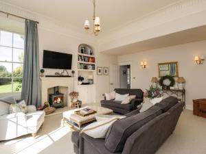 a living room with a couch and a fireplace at Rockstowes House in Dursley