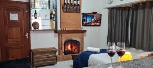 a living room with two wine glasses and a fireplace at Do Sonho a Realizacao in Monte Verde