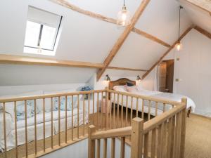 a loft bedroom with a bed and a crib at Rockstowes House in Dursley
