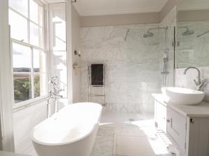 a white bathroom with two sinks and a shower at Rockstowes House in Dursley