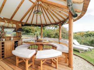 an outdoor dining area with a wooden gazebo at Rockstowes House in Dursley