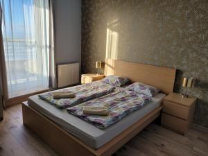 a bedroom with a bed with two pillows on it at Club218 Wellness Apartments in Siófok